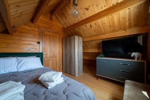1 dormitorio con 1 cama y TV de pantalla plana en Ktima to Alliotiko at Lofou Village en Lofou