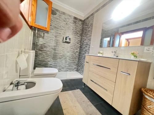 a bathroom with a sink and a toilet and a mirror at La Graciosita Traditional Home in Caleta de Sebo