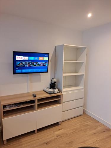 un salon avec une télévision sur un mur dans l'établissement Studio avec Terrasse à 5 minutes de la plage N6, à Saint-Laurent-du-Var