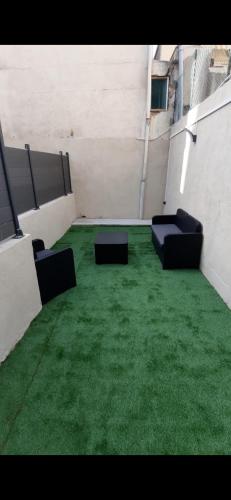 une pièce vide avec des chaises et de l'herbe verte dans l'établissement Studio avec Terrasse à 5 minutes de la plage N6, à Saint-Laurent-du-Var