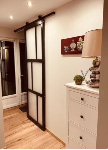 une chambre avec une porte et une commode avec une lampe dans l'établissement Hébergement Cosy avec terrasse Tropézienne, à Le Chambon-Feugerolles