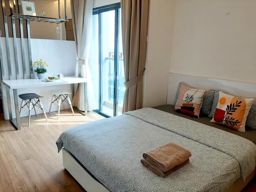 a bedroom with a bed and a table and a desk at Symphony Tower Studio #9 with balcony in Cheras