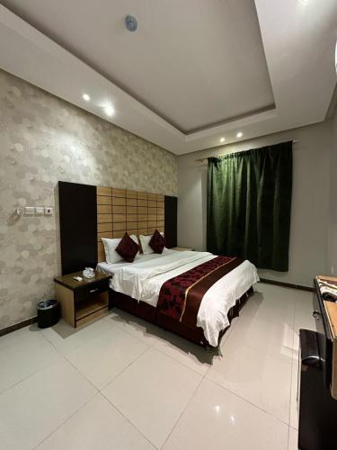 الجود للوحدات السكنية في الرياض: غرفة نوم بسرير كبير وطاولة