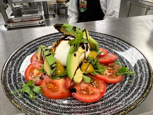 a plate of food with tomatoes and avocado on a counter at HHotel Augsburg in Augsburg
