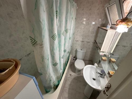 a bathroom with a sink and a toilet and a shower curtain at 2 bedroom apartment with sea view in Kyrenia centre in Kérynia