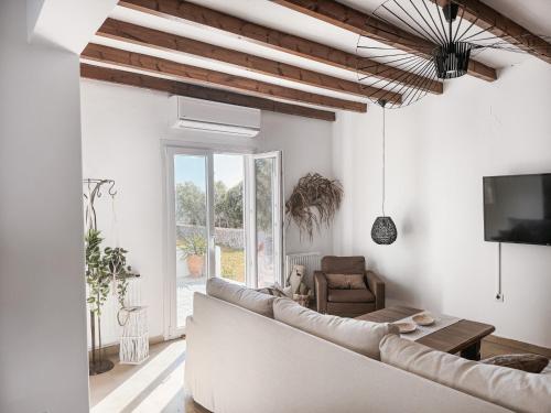 uma sala de estar branca com um sofá e uma televisão em The Mykonos House - Newly Renovated Villa Near Town em Míconos