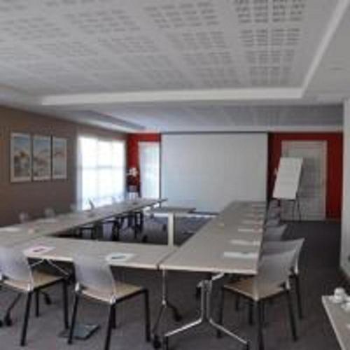 a room with tables and chairs in a classroom at Fasthotel Toulouse Blagnac Aéroport in Blagnac