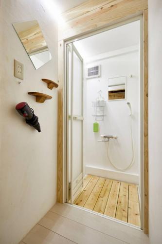 Habitación con puerta que da a un baño con ducha. en ゲストハウス　グランフォティア, en Yamagata