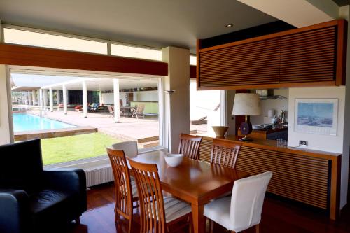 a dining room with a table and a view of a pool at Villa Temptation in Kamena Vourla