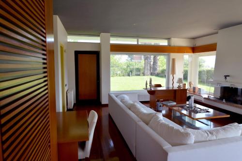 a living room with a white couch and a table at Villa Temptation in Kamena Vourla