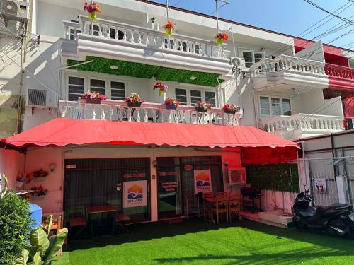 a building with a red awning in front of it at Sea View Jomtien Guest House in Jomtien Beach