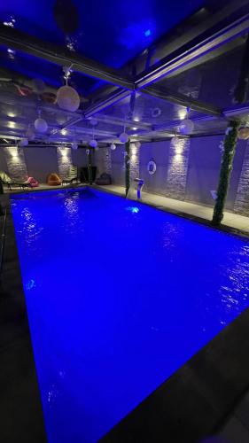 a swimming pool in a room with blue lighting at Everst Top1شاليه جرش in Jerash