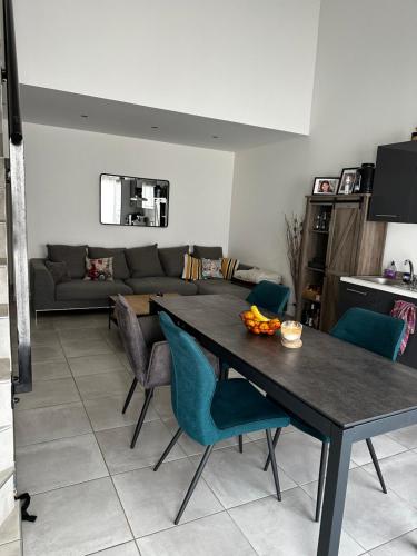 ein Wohnzimmer mit einem Tisch, Stühlen und einem Sofa in der Unterkunft APPARTEMENT PLEIN CENTRE in Bernis