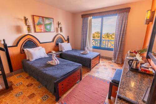 a living room with two beds and a window at Faraana Heights Aqua Park in Sharm El Sheikh