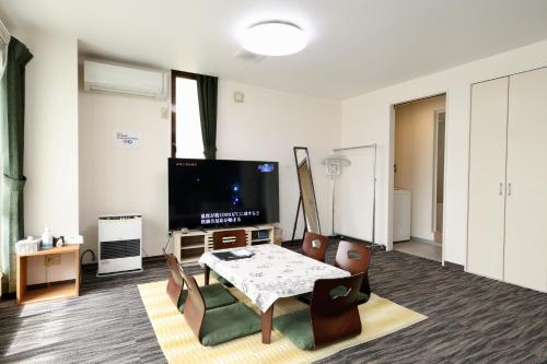 a living room with a table and a tv at Apartment Susukino Hakuhou Building in Sapporo