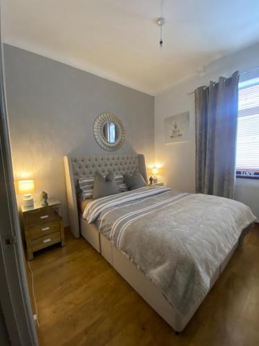 a bedroom with a large bed with a mirror on the wall at Beautiful Views Welsh Valley home in Mountain Ash