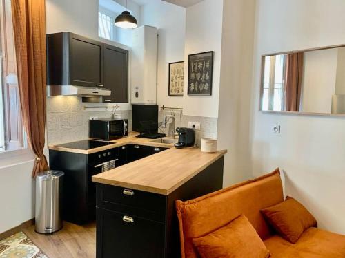 uma pequena cozinha com um balcão e uma bancada em L'Ambre - Appartement Raffiné em Perpignan