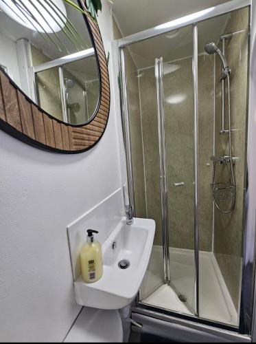 a bathroom with a shower and a sink and a mirror at Stylish Studio Stevenage in Stevenage