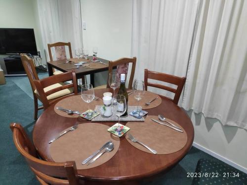 una mesa de madera con sillas y una mesa con copas de vino en Macks Alpine Chalet And Spa Pool, en National Park