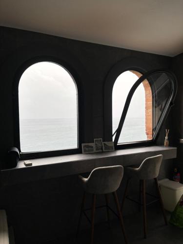 ラヴェッロにあるChez-Lu Ravelloのカウンターと椅子2脚付きの部屋(窓2つ付)