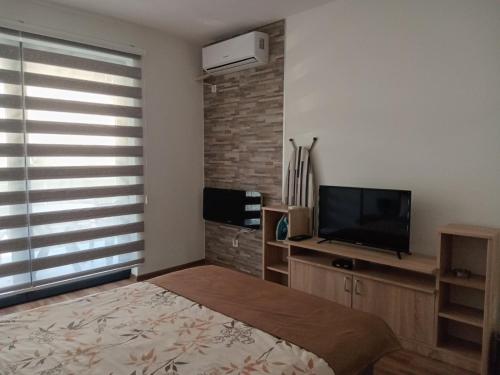 1 dormitorio con 1 cama y TV de pantalla plana en Apartments Karić Aerodrom Tuzla en Dubrave Gornje