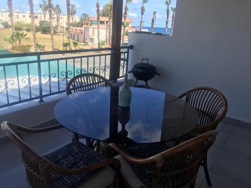 a table and chairs on a balcony with a view of the ocean at Latchi Holiday Flat in Polis Chrysochous