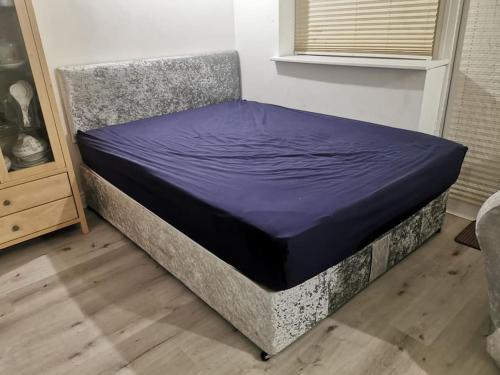 a bed in a room with a purple mattress at 3 Bedroom Home Near Windsor Castle, Legoland, & Heathrow in Slough