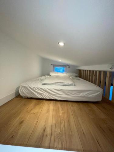 Cette chambre comprend un grand lit et du parquet. dans l'établissement Appartement 3 pièces à 5 minutes de la plage N7, à Saint-Laurent-du-Var