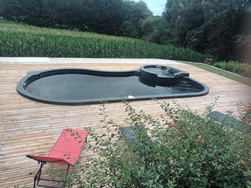 - une petite piscine sur une terrasse en bois avec une chaise dans l'établissement Salegourde, à Proissans