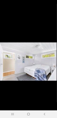 a white bedroom with two beds and a desk at Hytte ved elv in Hektner