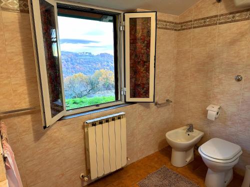 ein Bad mit einem WC und einem Fenster in der Unterkunft Villetta nel bosco tra Firenze Arezzo e Siena in Terranuova Bracciolini