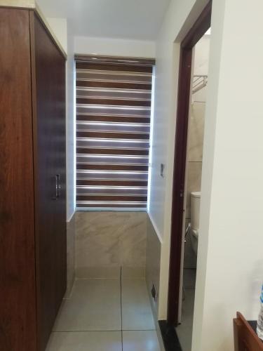 a bathroom with a closet and a window with blinds at PAUL RESIDENCY in Nedumbassery