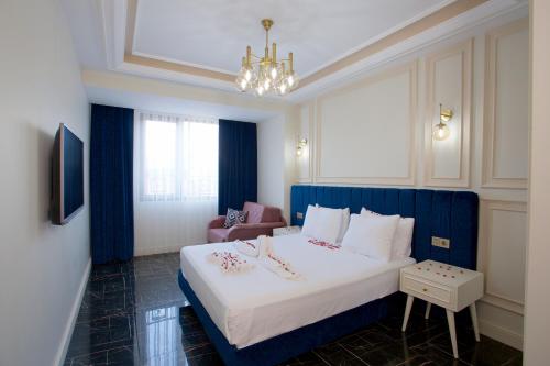 Schlafzimmer mit einem großen weißen Bett mit blauem Kopfteil in der Unterkunft Princely Suites in Istanbul