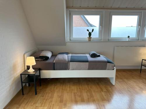 a bedroom with a bed and two windows at Worker Place mit Wintergarten in Goch