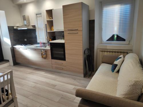uma sala de estar com um sofá e uma cozinha em Il Sole dell' Altopiano em Villa Opicina