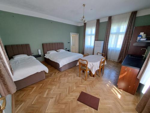 a hotel room with two beds and a table at Eagles Court - Orlovski Vrt in Staji°evo
