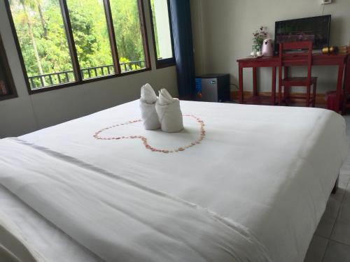 dwa wypchane zwierzęta siedzące na łóżku w obiekcie Vang Vieng Champa Hotel w mieście Vang Vieng