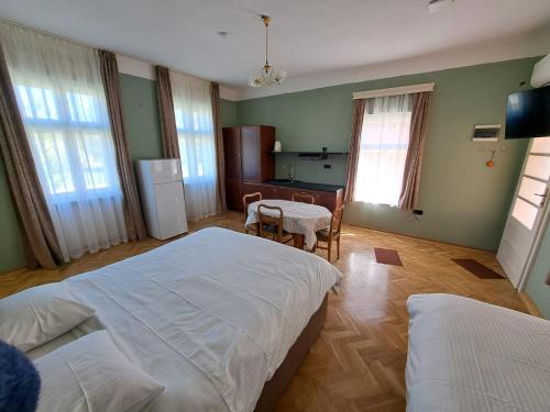 a bedroom with two beds and a table and a kitchen at Eagles Court - Orlovski Vrt in Staji°evo
