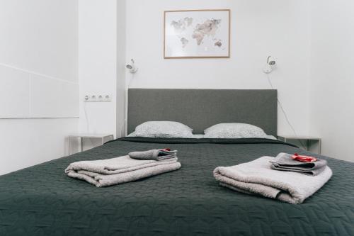 a bedroom with a bed with towels on it at City Center Maakri Apartment in Tallinn