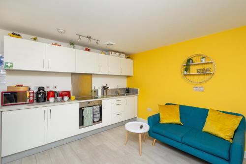 a living room with a blue couch in a kitchen at Wakefield Westgate Station - Off Road Parking, Self Check-in, Fast Wi-Fi - Families, Contractors, Long Stays in Wakefield
