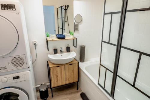 ein Badezimmer mit einem Waschbecken und einer Waschmaschine in der Unterkunft Aux portes de Bordeaux/\Les Carrelets/\MindUrGuest in Lormont