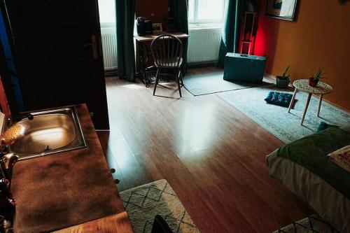 a living room with a wooden floor and a table at Sahara studio with shared bathroom in city centre in Bratislava