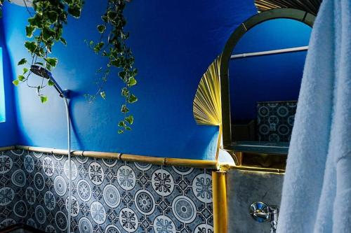 uma casa de banho com um espelho e uma parede azul em Sahara studio with shared bathroom in city centre em Bratislava