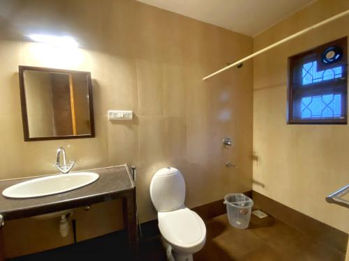 een badkamer met een wit toilet en een wastafel bij Quintara Serviced Apartments in North Goa in Porvorim