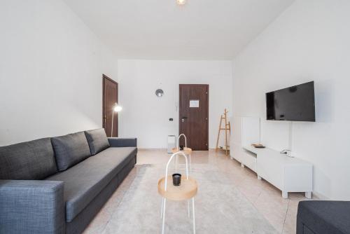 a living room with a couch and a tv at Roma 23, SmartStay Rozzano in Rozzano