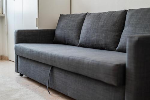 a gray couch sitting in a living room at Roma 23, SmartStay Rozzano in Rozzano