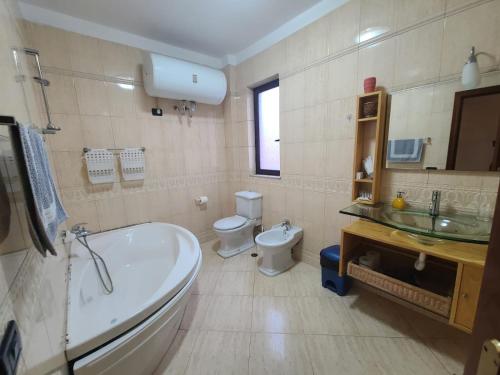 a bathroom with a tub and a toilet and a sink at Villa My Apartments in Tirana