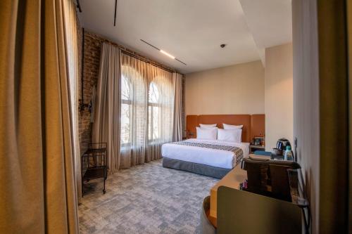 a hotel room with a bed and a desk at Qarvasla Hotel in Tbilisi City