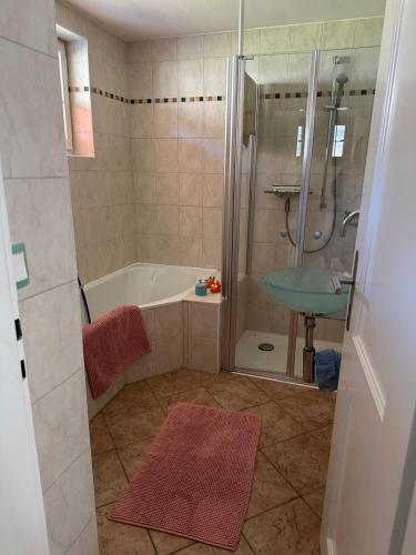een badkamer met een douche, een bad en een wastafel bij Am Ampferang:Ferienhaus in Ettal in Ettal