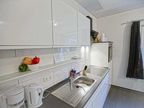a kitchen with a sink and a counter with fruits at Ground floor apartment with terrace and large garden with lounge area and grill in Mönkebude